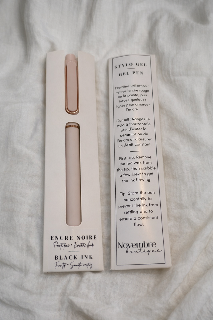 Pen in packaging with November Boutique branding on a textured surface