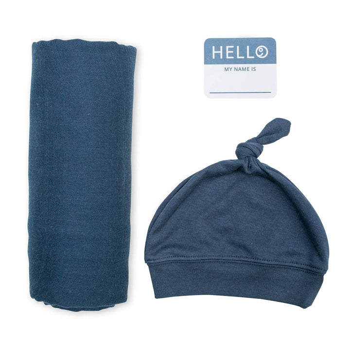 Blue baby swaddle blanket and hat set with a name tag on a white background