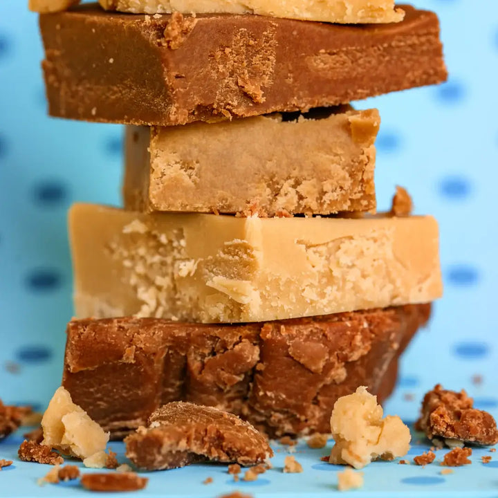 Stack of layered chocolate and peanut butter bars on a blue background