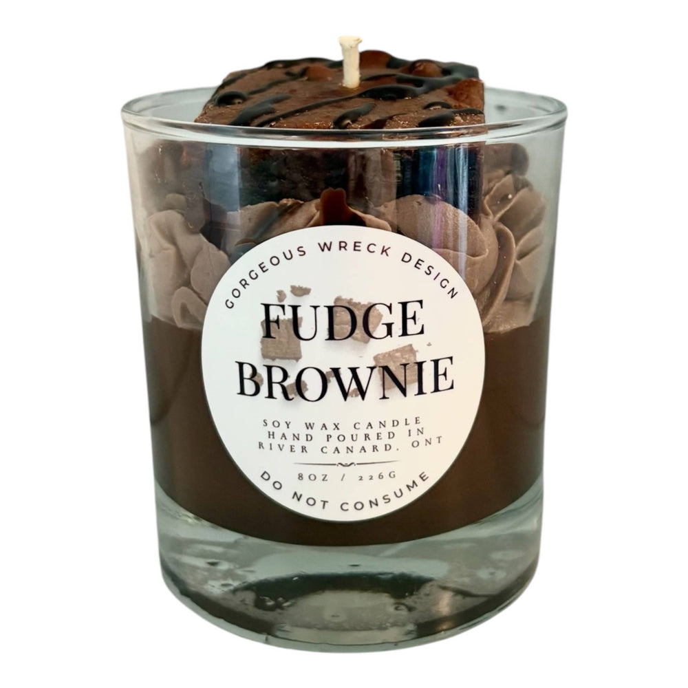 Fudge brownie candle in a glass jar with a decorative label on a white background