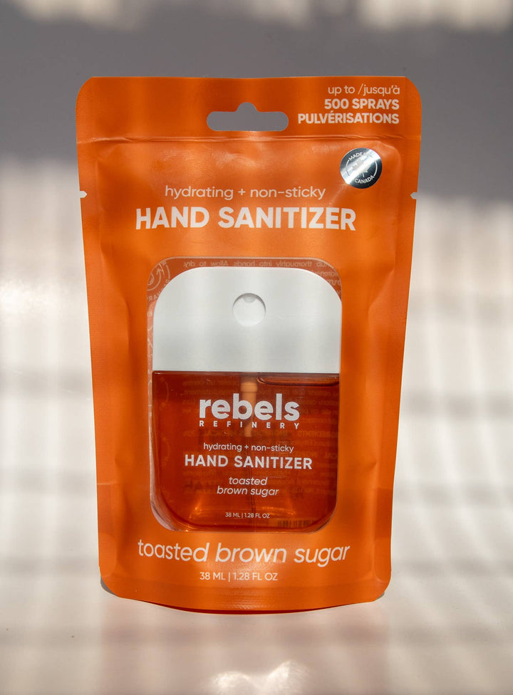 Orange package of rebels Toasted Brown Sugar hand sanitizer on a gray background