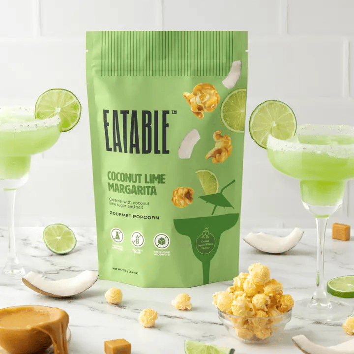 Eatable Coconut Lime Margarita popcorn package with popcorn and drinks on a white background