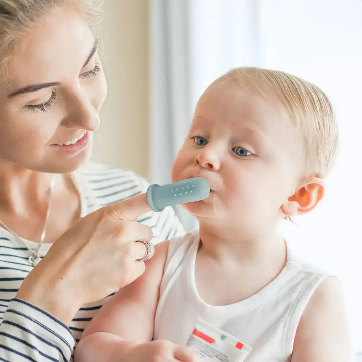 Woman assisting a child with a blue device on a white background