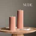 Set of two nude ribbed pillar candles by Estelle Studio, showcasing textured design and elegant candle shapes.