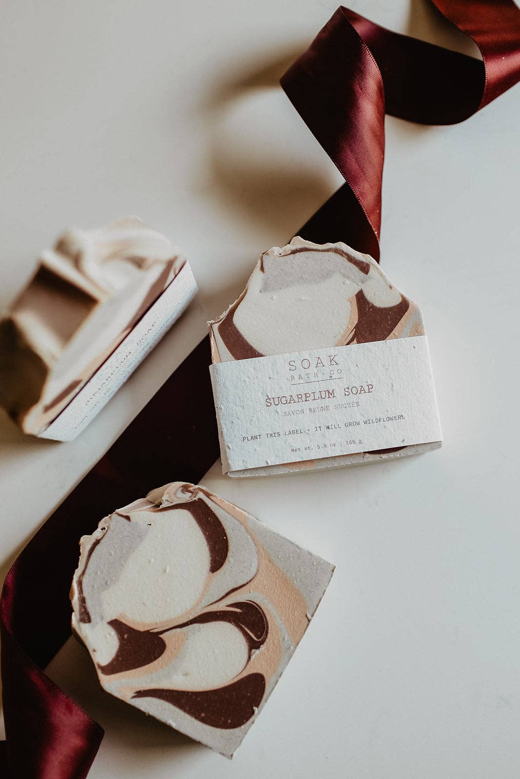 Three artisanal marbled soap bars with a white paper label reading &