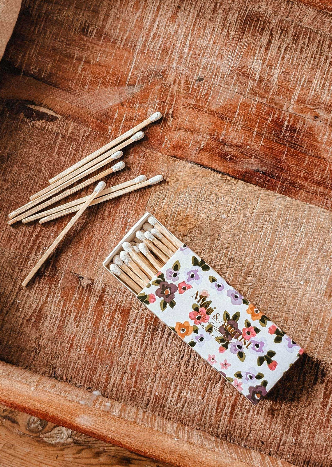 Matches with floral patterned box on a wooden surface