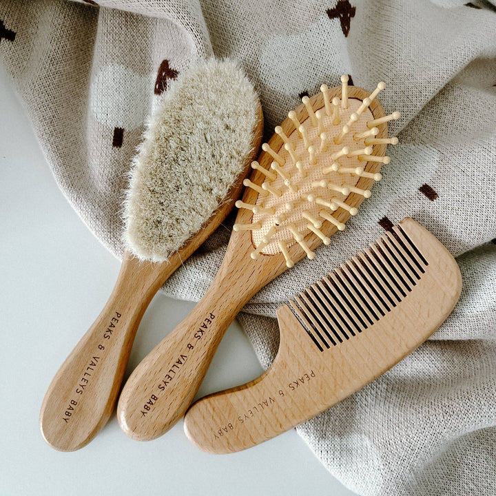 Three wooden hair care tools on a textured fabric background