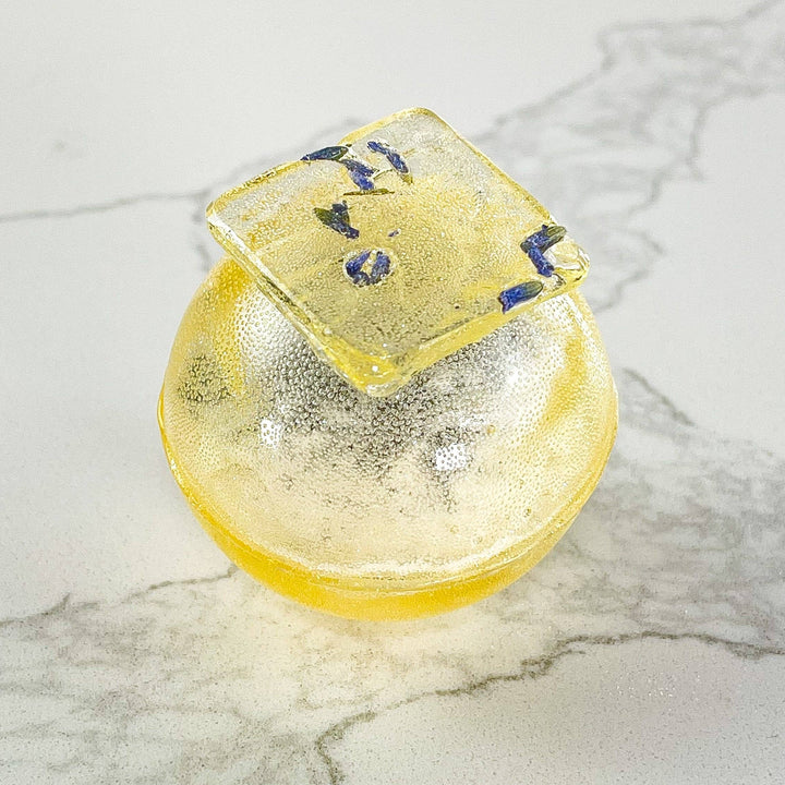 Yellow soap bar with blue design on a marble surface