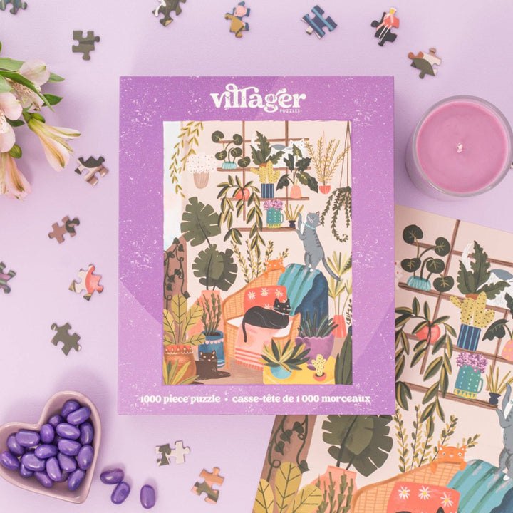 Villager puzzle box with a colorful illustration of a room with plants and cats on a purple background.