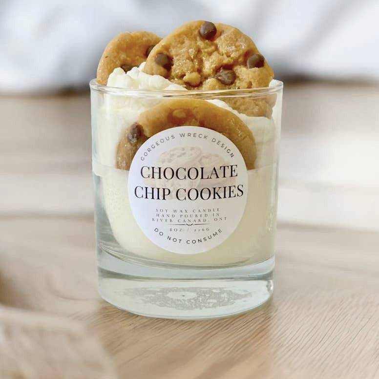 Candle in a glass jar with chocolate chip cookies on top, labeled &