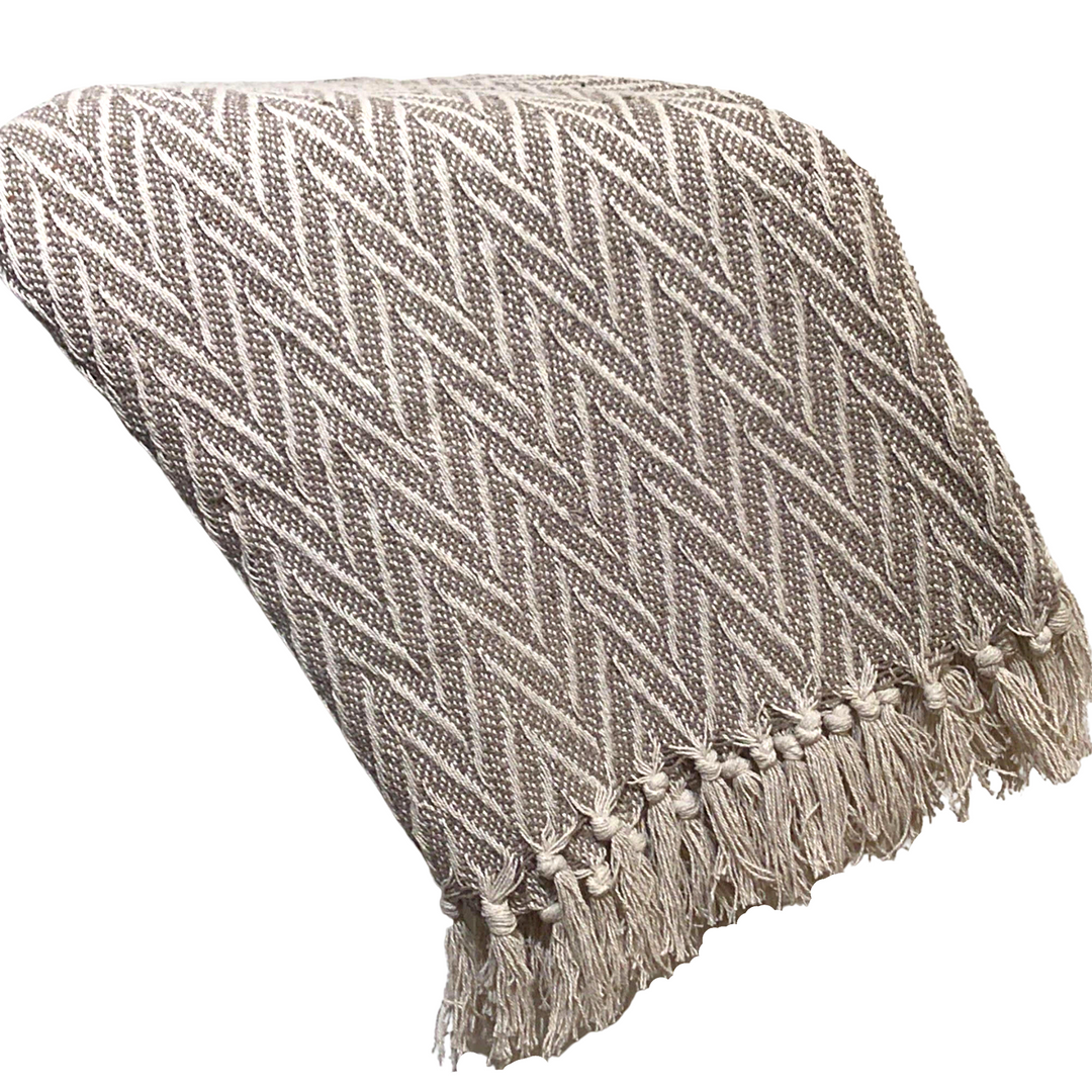 A woven throw blanket with a textured herringbone pattern in taupe and cream, finished with a fringed edge, shown on a solid white background.