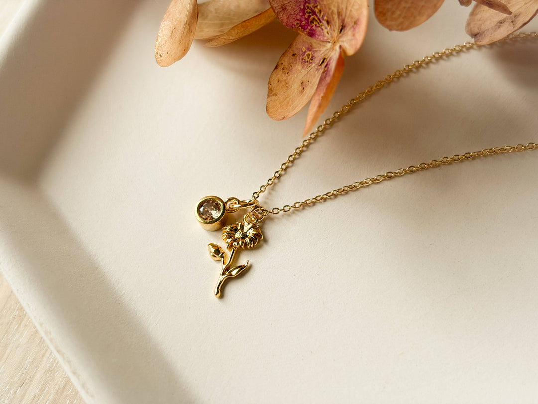 Gold necklace with a delicate pendant on a light surface