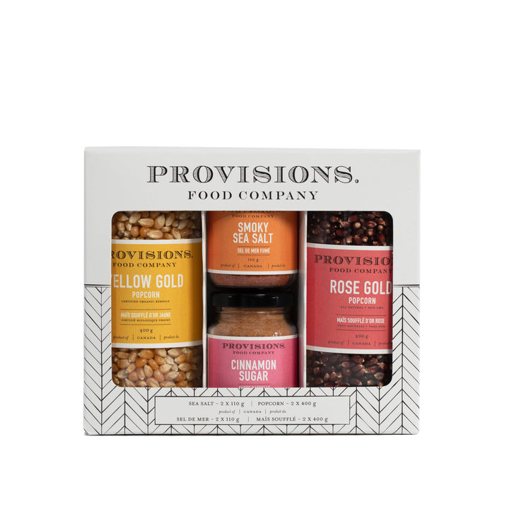 Provisions Food Company gift set containing three jars of gourmet snacks and seasonings: Yellow Gold Popcorn, Smokey Sea Salt, and Rose Gold Popcorn with Cinnamon Sugar. The set is packaged in a white box with black and gray geometric patterns.