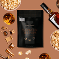 Eatable Gourmet Popcorn 'Whisky on the Pops' package with popcorn, whisky, and candies on a brown background