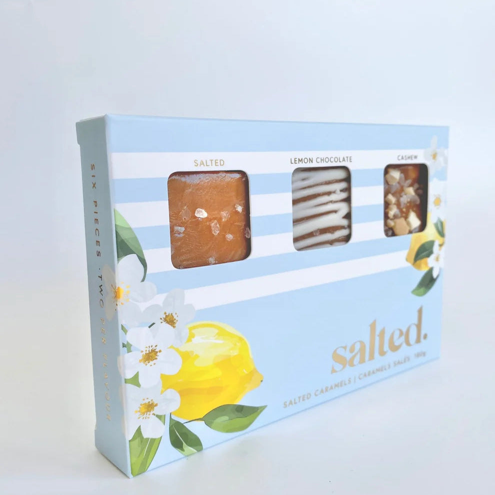 Box of salted lemon chocolates with lemon and flower design on a light gray background