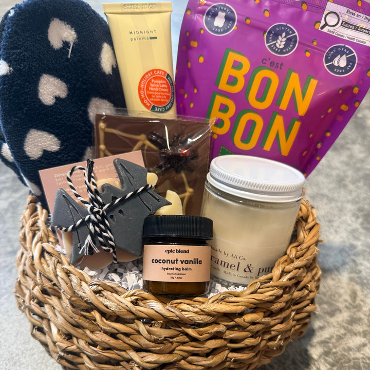 A curated gift basket containing a purple bag of c&